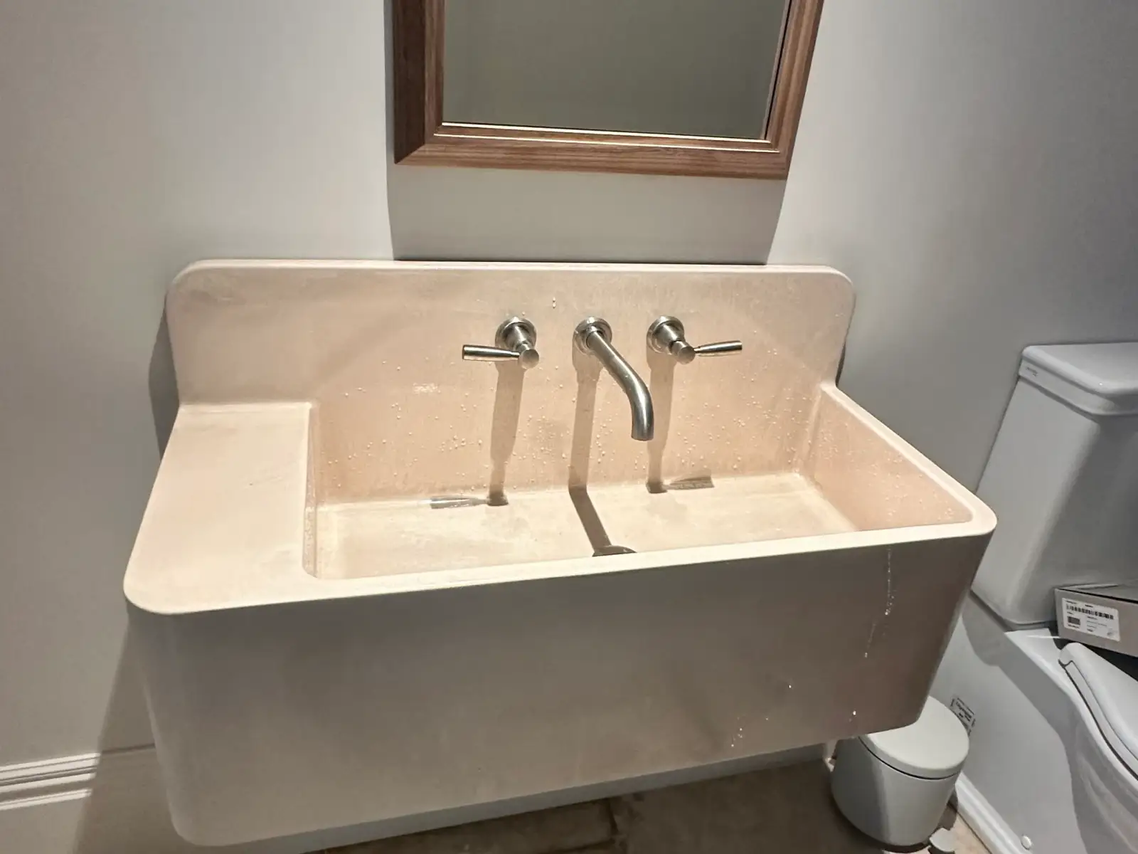 Newly installed rainfall shower head and mixer in a finished tiled bathroom